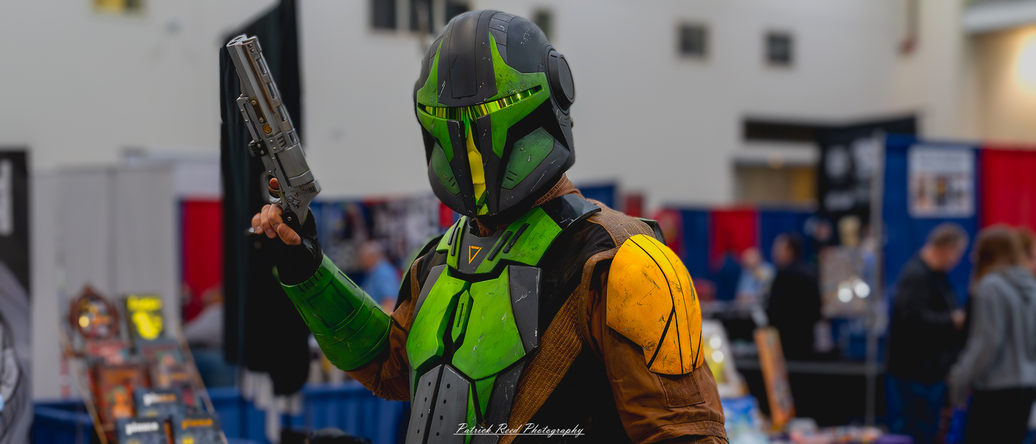 "Cosplayer dressed in green Mandalorian armor, complete with a helmet, chest plate, and matching accessories, embodying the iconic warrior from the Star Wars universe."